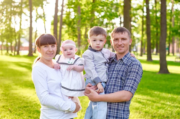 Happy young family with children walks in the summer park — Stock Photo, Image