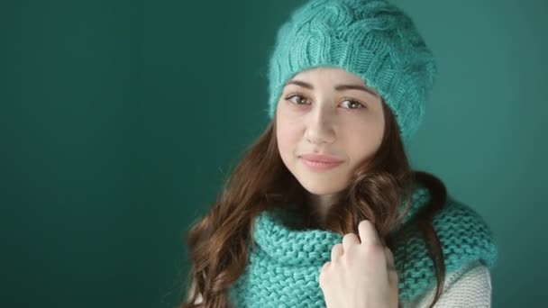Hermosa mujer joven en un sombrero de punto turquesa y bufanda — Vídeos de Stock