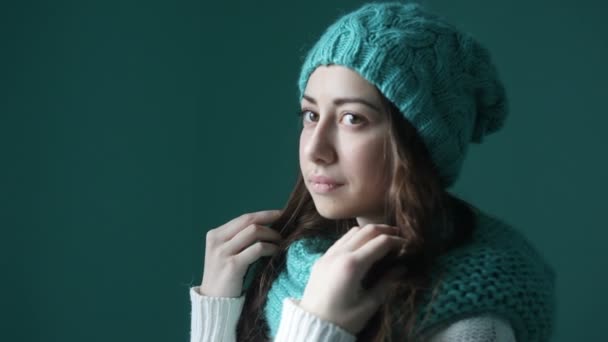 Красивая молодая женщина в бирюзовой вязаной шляпе и шарфе — стоковое видео
