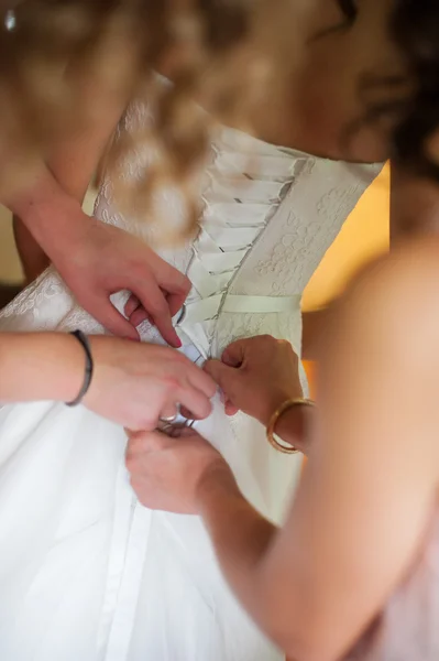 Portrait demoiselle d'honneur aider la mariée avec sa robe — Photo
