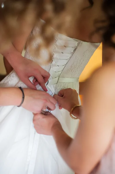 Retrato dama de honor ayudando a la novia con su vestido — Foto de Stock