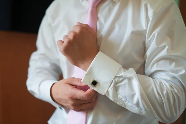 Man sätter på sin skjorta manschetter morgon brudgummen tillbehör — Stockfoto