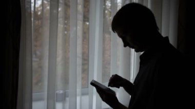 Cep telefonu kullanarak bir adam silüeti