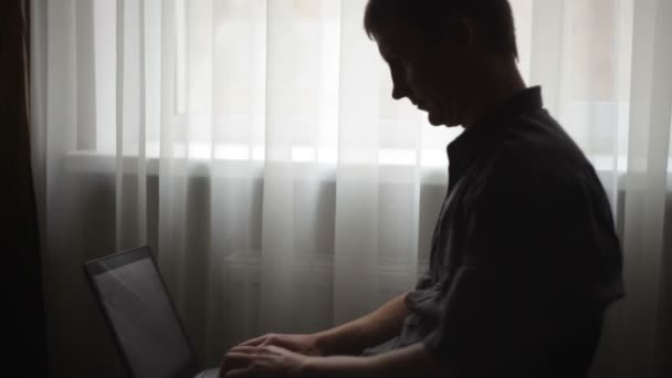 Man spelen op een laptop in de kamer — Stockvideo