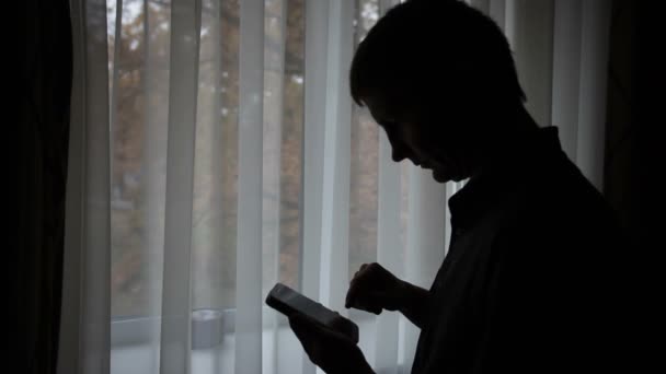 Silueta de un hombre mediante el uso de teléfono móvil — Vídeo de stock