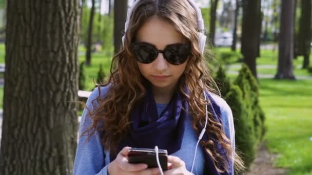 Mulher bonita com um smartphone ouvindo música — Vídeo de Stock