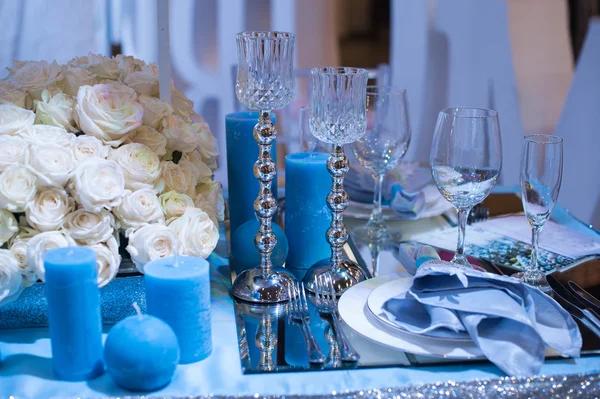 Bruiloft decor in blauw. kaarsen en bloemen op tafel — Stockfoto