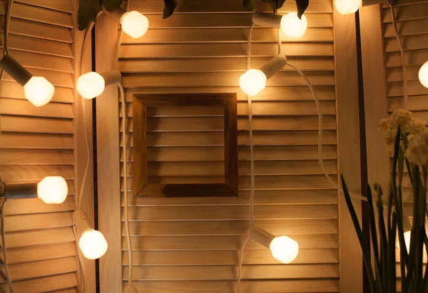 Декоративные лампочки и рамка для фото в деревянном интерьере — стоковое фото