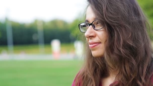 Mooie vrouw in glazen poseren in de zomer park — Stockvideo