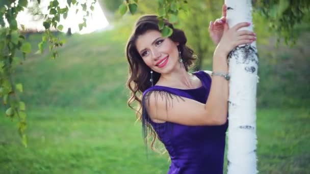 Νεαρή όμορφη γυναίκα κοντά η σημύδα στο καλοκαίρι πράσινο πάρκο — Αρχείο Βίντεο