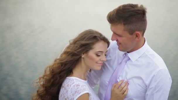 Елегантний стильний наречений зі своєю щасливою розкішною брюнеткою нареченої на фоні озера — стокове відео