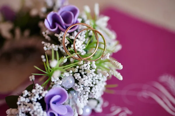 Bruiloft corsages van bloemen en gouden ringen — Stockfoto