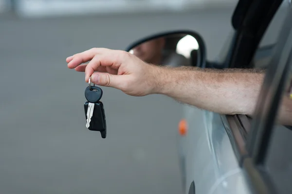 Mens mano in possesso di una chiave dalla macchina, simboleggiano gioia acquisto trasporto, accreditamento, guida — Foto Stock