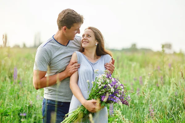 Jovem casal apaixonado andando no prado de verão — Fotografia de Stock