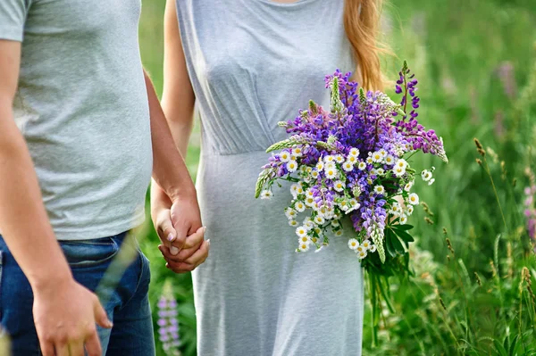 Jeune couple amoureux marchant sur la prairie d'été — Photo