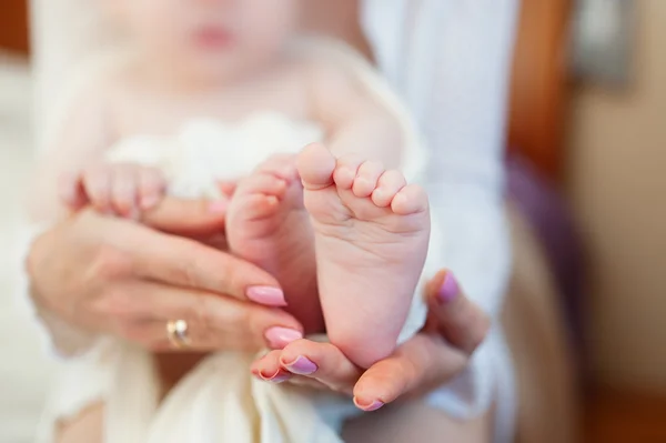 Mother holding little babys feet on bed — Stock Photo, Image