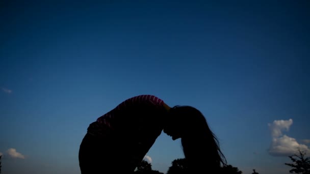 Silhouette d'une femme aux cheveux longs lève la tête contre le ciel — Video