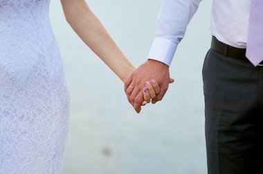 Gelin ve damat el ele tutuşarak düğün fotoğrafı