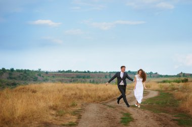 Groom catches bride on the summer field clipart