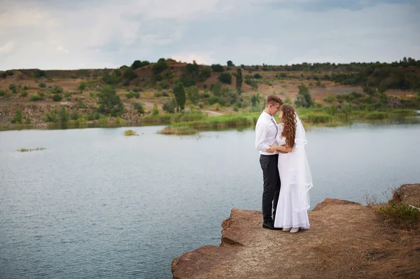 美丽的年轻夫妇在婚礼那天在湖边散步 — 图库照片
