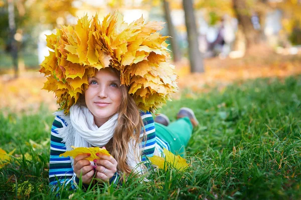 Beautiful woman with a wreath of yellow leaves in the park — Stock Photo, Image