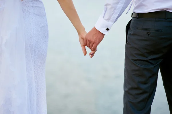 Wedding photo of bride and groom holding hands — Stock Photo, Image