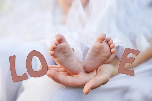 Mor hand som håller små baby fötter — Stockfoto