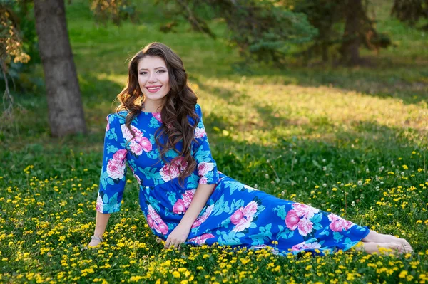 Beautiful woman lying on green grass in the park — Stock Photo, Image