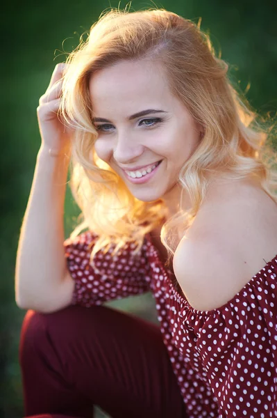 Happy smiling woman in a park on the grass — Stock Photo, Image