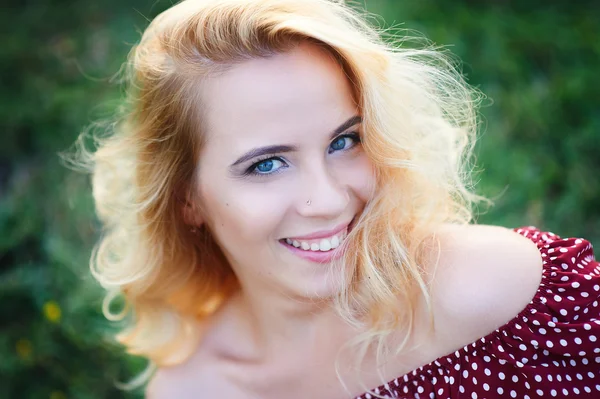 Happy smiling woman in a park on the grass — Stock Photo, Image