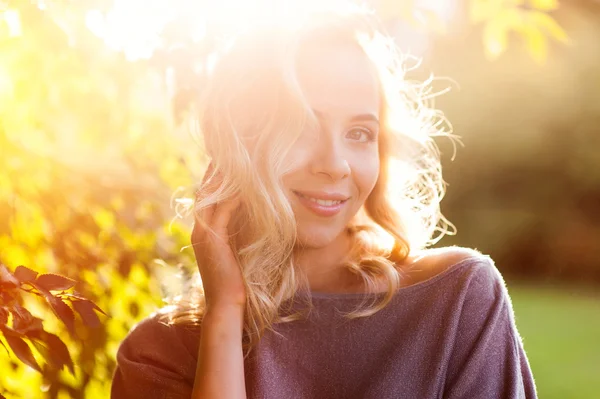 Schöne Frau auf dem Hintergrund der untergehenden Sonne — Stockfoto