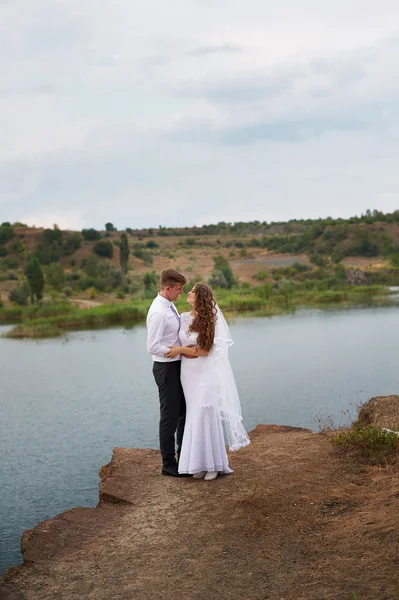 爱新娘和新郎在背景湖上行走 — 图库照片