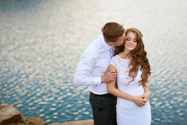 Amorevole sposa e sposo a piedi su uno sfondo di lago — Foto Stock
