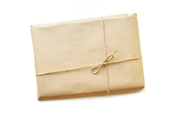 Rustieke geschenkdoos verpakt in bruin papier gebonden door touw met blanco op witte achtergrond met ruimte voor tekst — Stockfoto