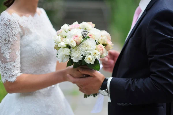 Pan młody daje pannie młodej zbliżenie piękny bukiet ślubny. Na spacer po parku — Zdjęcie stockowe