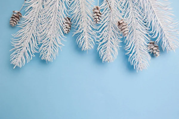 メリークリスマスとハッピーニューイヤーグリーティングカードの枝フレームやバナー。青い背景の上面のビューにモミの木。冬休みのテーマ — ストック写真