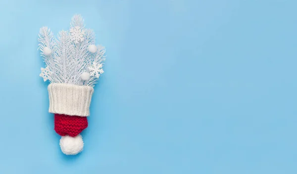 Cartão de felicitações de Natal com chapéu vermelho e ramos de abeto branco e flocos de neve no fundo azul. Natal cartão postal de férias com lugar para o seu texto. Feliz Ano Novo — Fotografia de Stock