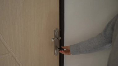 Ofisteki beyaz ahşap kapıyı açan ve kapatan kadın. Kapı kolunu tutuyorum. Tam HD video hareketi