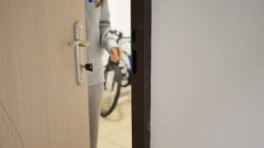 Ofisteki beyaz ahşap kapıyı açan ve kapatan kadın. Kapı kolunu tutuyorum. Tam HD video hareketi