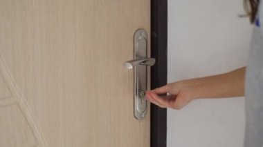 Ofisteki beyaz ahşap kapıyı açan ve kapatan kadın. Kapı kolunu tutuyorum. Tam HD video hareketi