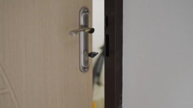 Ofisteki beyaz ahşap kapıyı açan ve kapatan kadın. Kapı kolunu tutuyorum. Tam HD video hareketi