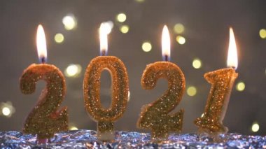 Mutlu yıllar 2021 kutlamaları. Noel arkaplanında 2021 numara şeklinde altın yanan mumlar.