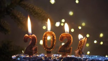 Tatil geçmişi. Mutlu yıllar 2021. 2021 yılının rakamları kırmızı şenlikli ışıl ışıl arka planda yanan altın mumlarla yapıldı. Yeni yılı kutluyoruz, yakın plan. Metin için boşluk