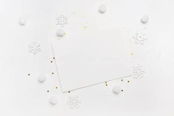 Carta navideña maqueta de copos de nieve y estrellas doradas sobre fondo blanco. Concepto de vacaciones de invierno. Vista superior plana con lugar para su texto — Foto de Stock