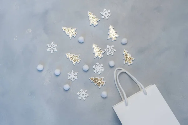 Χριστουγεννιάτικη ιδέα για ψώνια. Kraft λευκό πακέτο με νιφάδες χιονιού και έλατο δέντρο με θέση για το κείμενό σας σε γκρι φόντο. Το νέο έτος ήταν ψεύτικο. Άνω όψη — Φωτογραφία Αρχείου