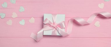 Kurdele ve kalp şeklinde konfeti içeren pankart kutusu pembe ahşap arka planda metnin için yer var. Sevgililer Günü 'nde, anneler gününde ya da doğum gününde modellik yap. Üst manzara, düz uzanma