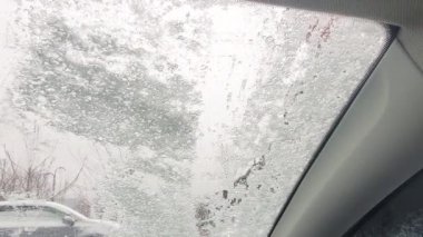 Adam arabasını kar fırçasıyla temizliyor. Kışın, kar fırtınasından sonra arabadan taze kar fırçalayan kişi. Soğuk kış havasında araba sahiplerinin sorunları