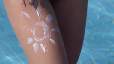 Güneş kremiyle boyanmış kadın bacağına.