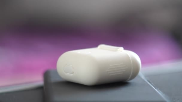 Bluetooth-hovedtelefoner i en hvid boks på en sort telefon – Stock-video