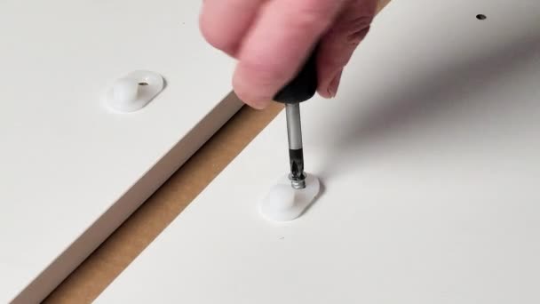 Sceny w domu montując mebel, biały człowiek naprawia wspornik śrubokrętem — Wideo stockowe